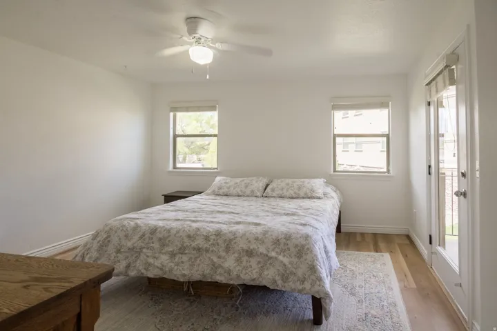 Bedroom with wood finished floors, ceiling fan, and access to exterior