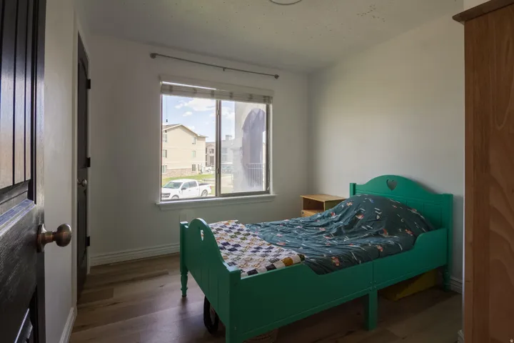 Bedroom featuring dark wood-style flooring and baseboards