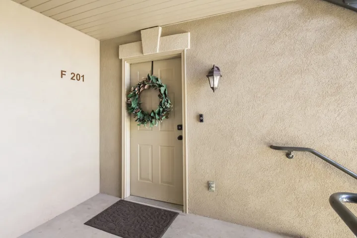 Entrance to property with stucco siding and a porch