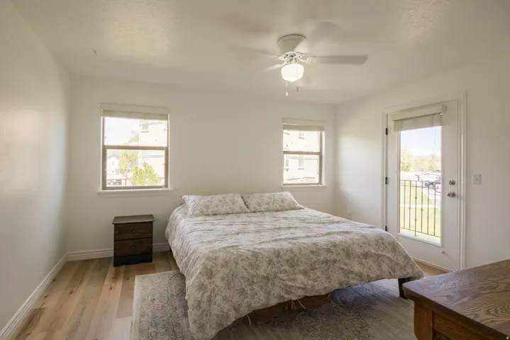 Bedroom featuring access to outside, light wood-style floors, multiple windows, and a textured ceiling