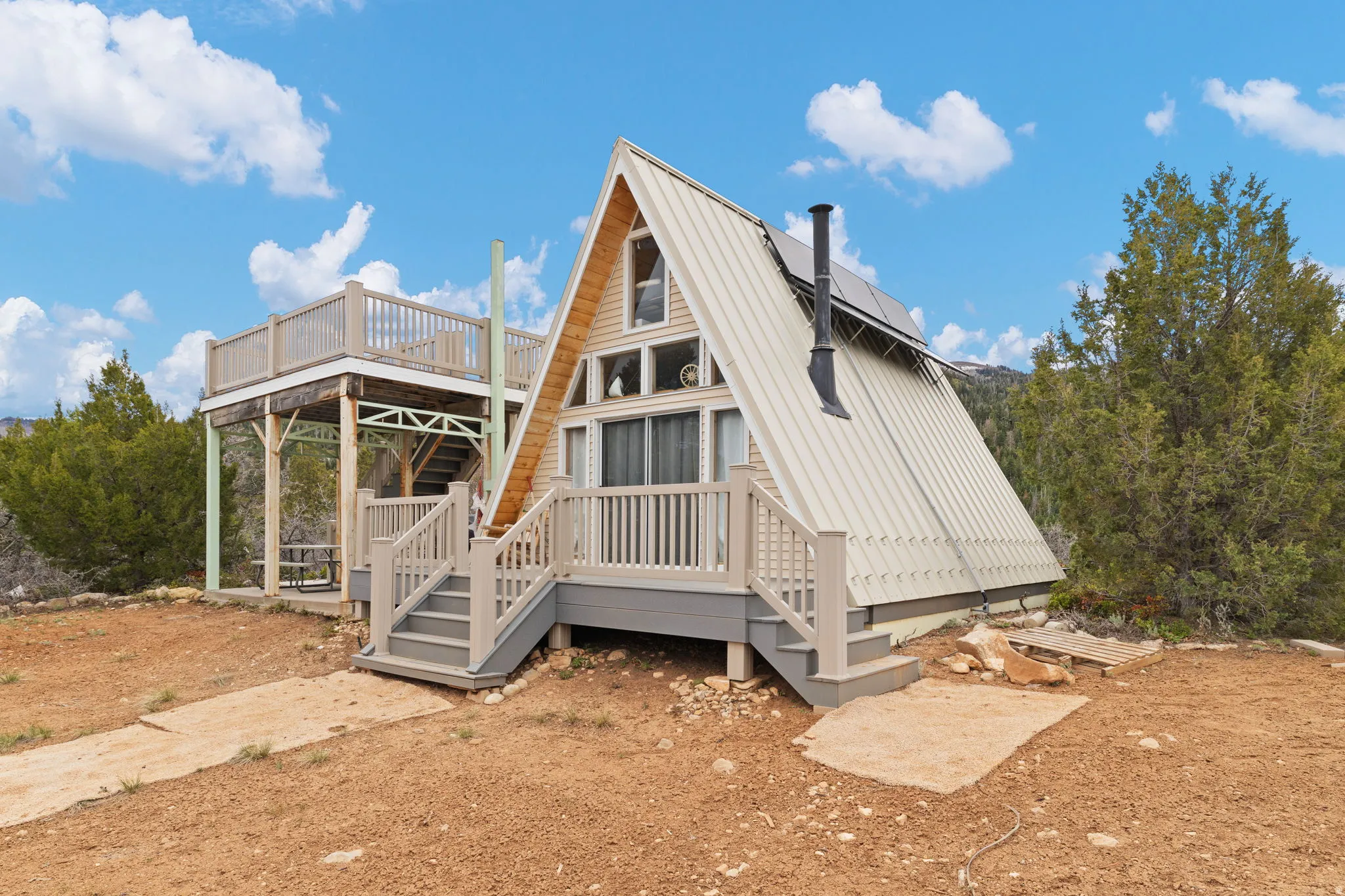 Rear view of house featuring a deck and a metal roof