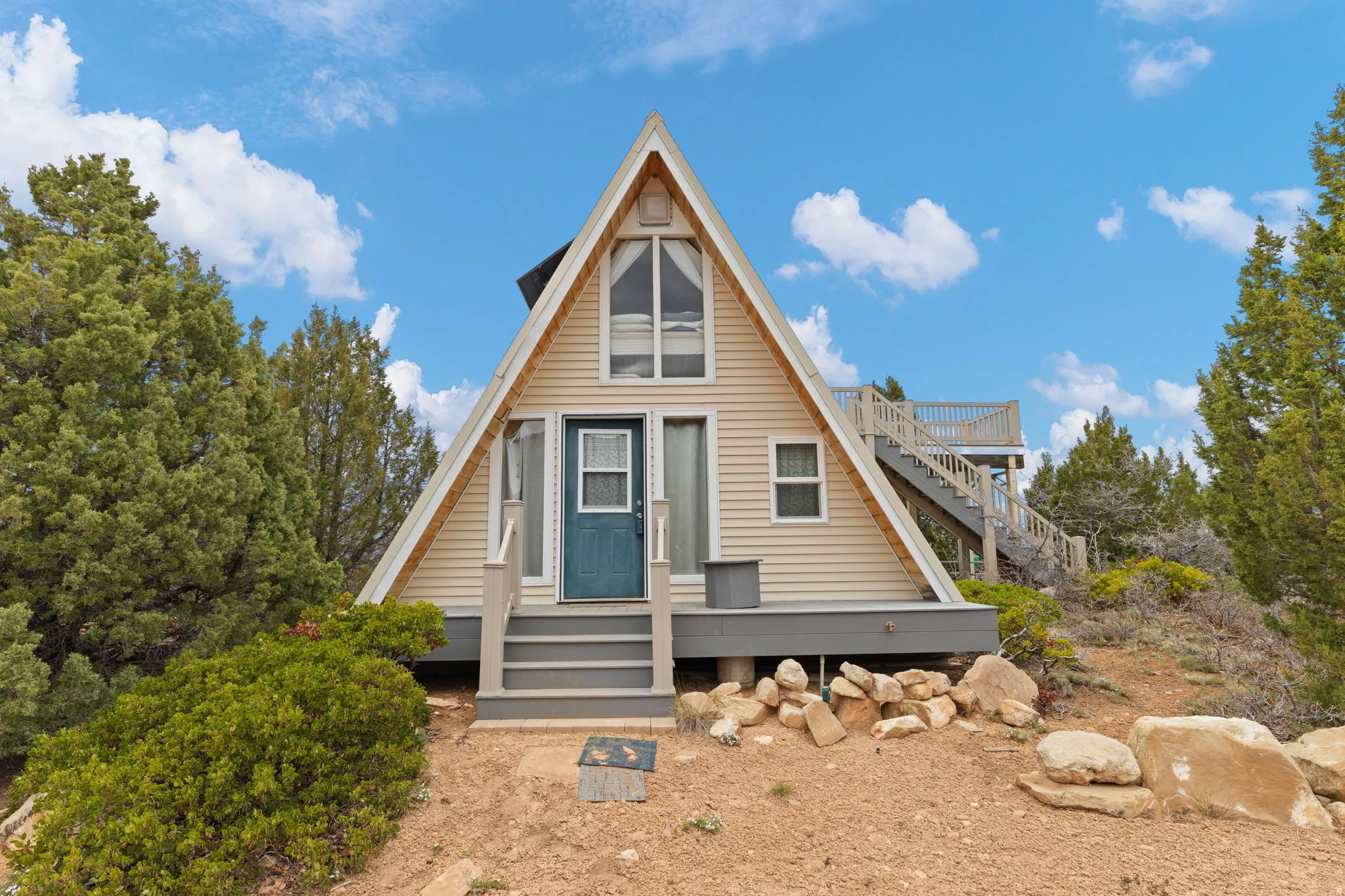 A-frame style home with stairway and a wooden deck