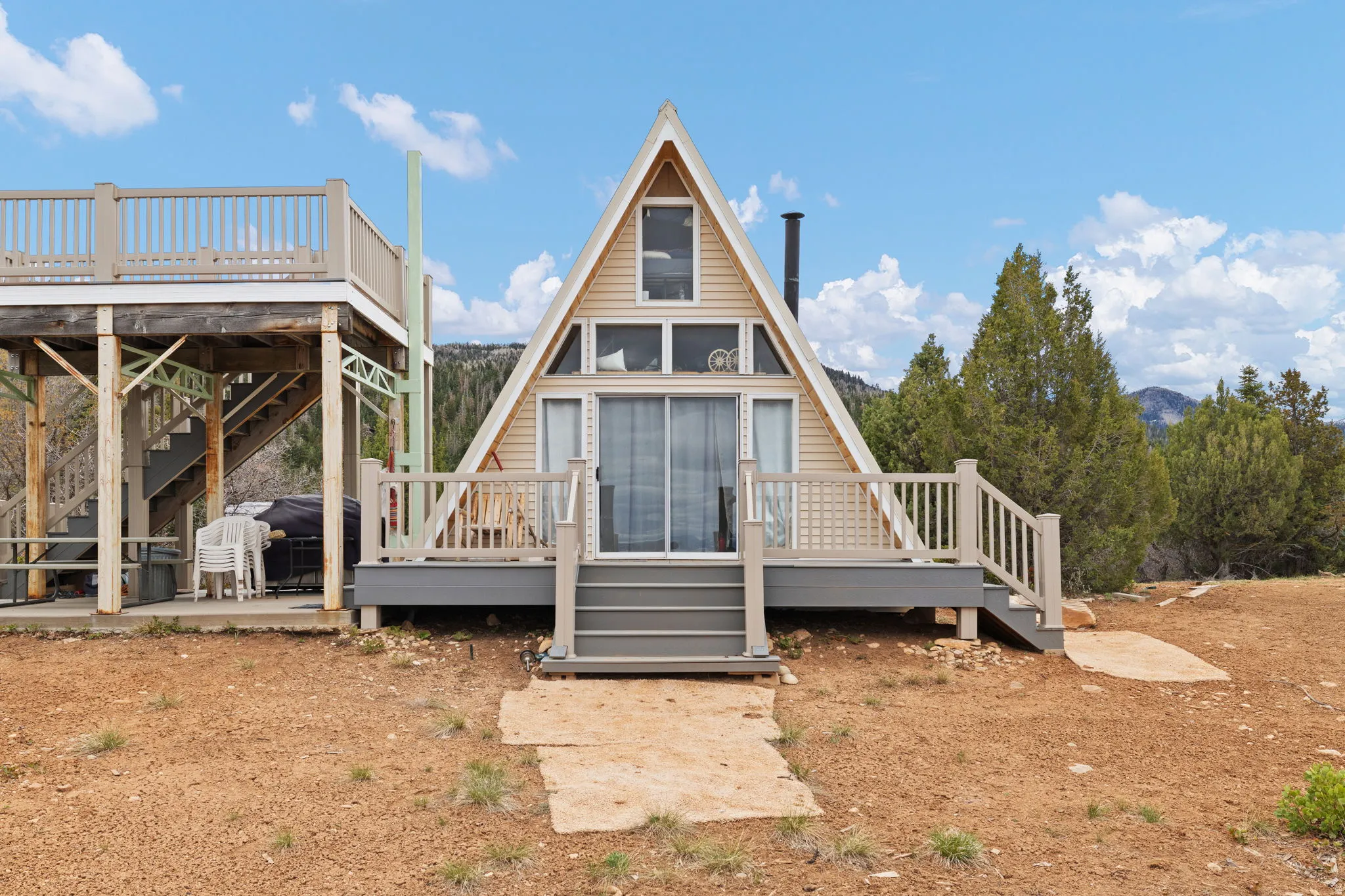 Back of house featuring stairs and a wooden deck