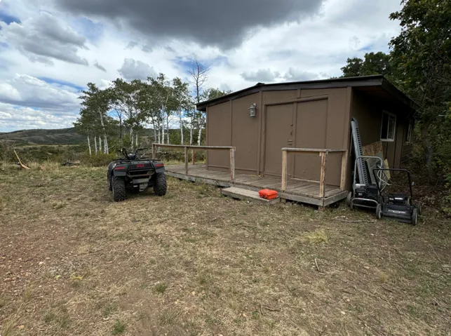 View of yard featuring a wooden deck and a shed
