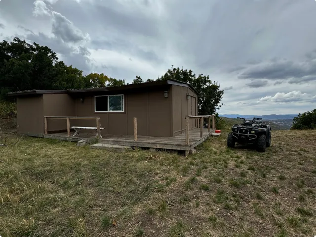 View of home's exterior with a wooden deck and a yard