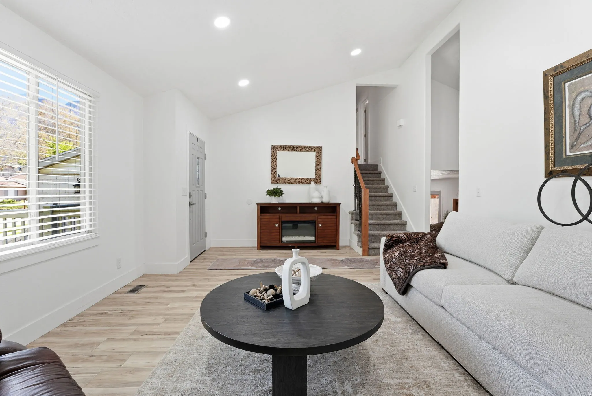 Living room featuring light wood finished floors, recessed lighting, and vaulted ceiling