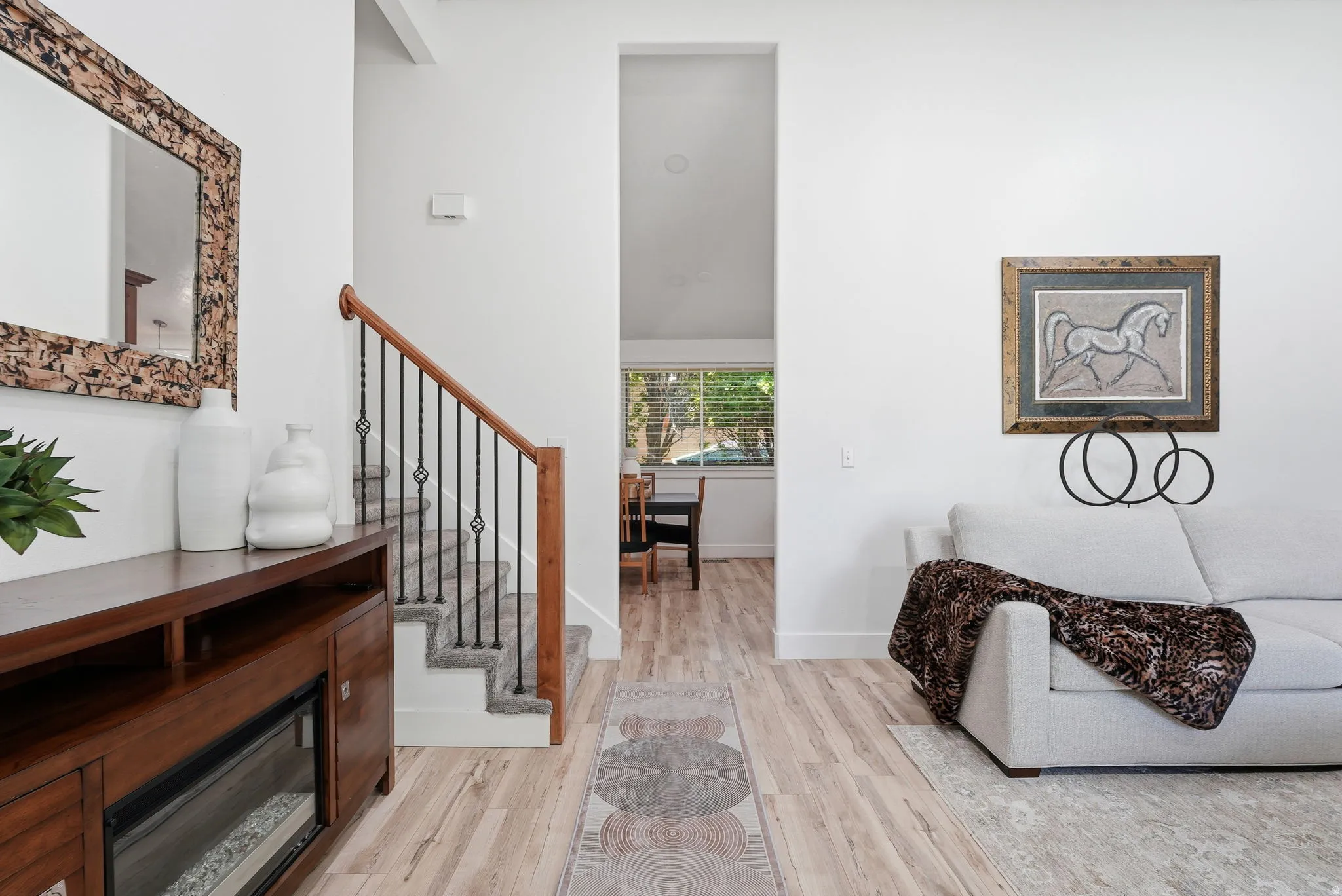Living room with light wood-style floors and stairway