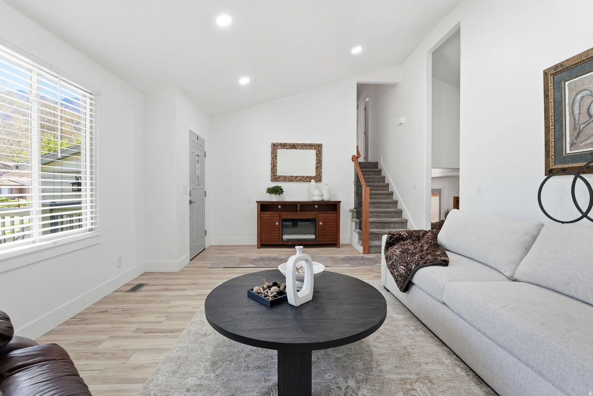 Living room with light wood-style floors, recessed lighting, and lofted ceiling