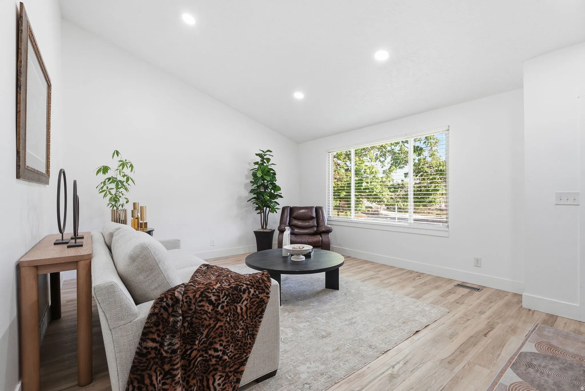 Living area with lofted ceiling, light wood finished floors, and recessed lighting