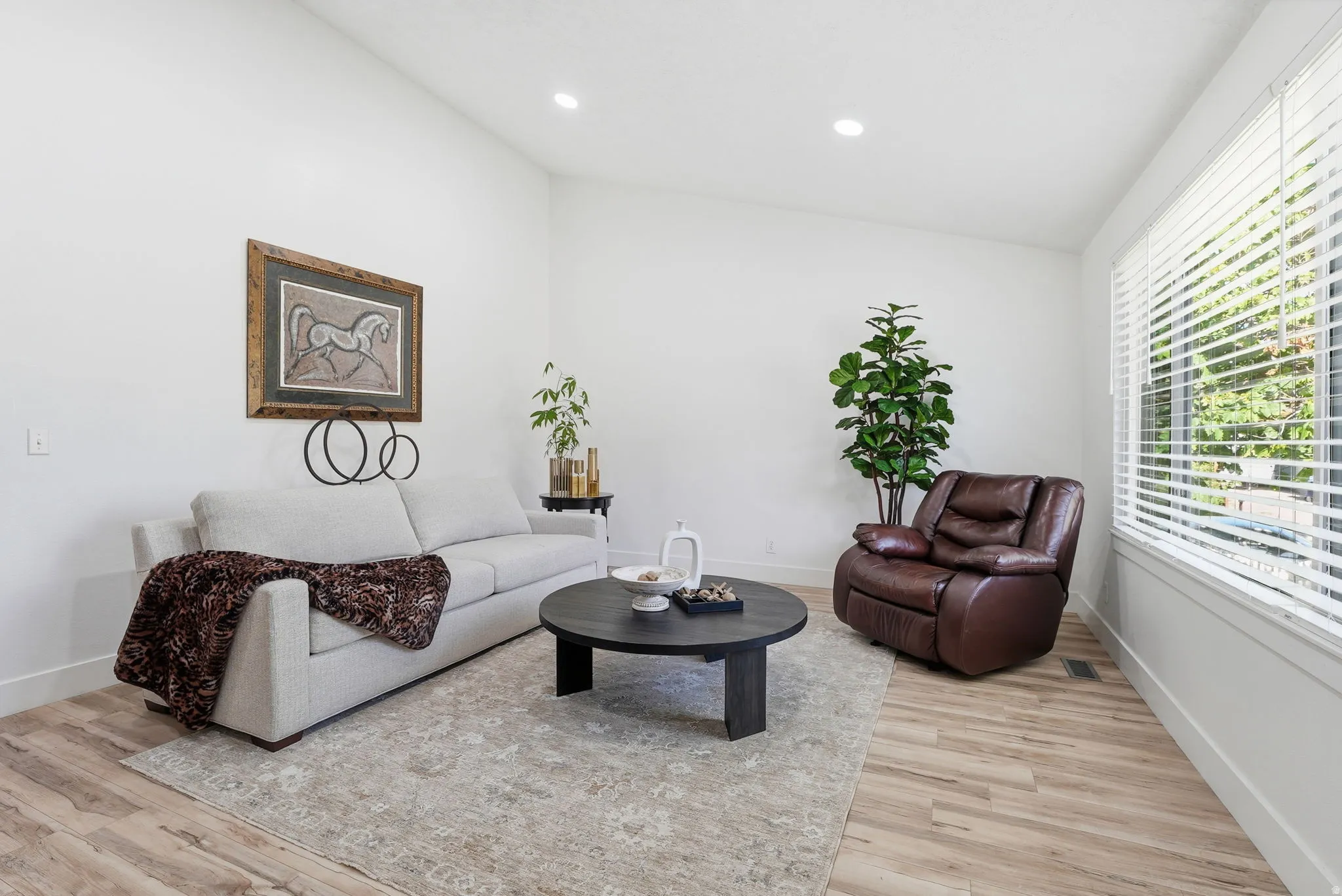 Living area with lofted ceiling, light wood-style floors, and recessed lighting