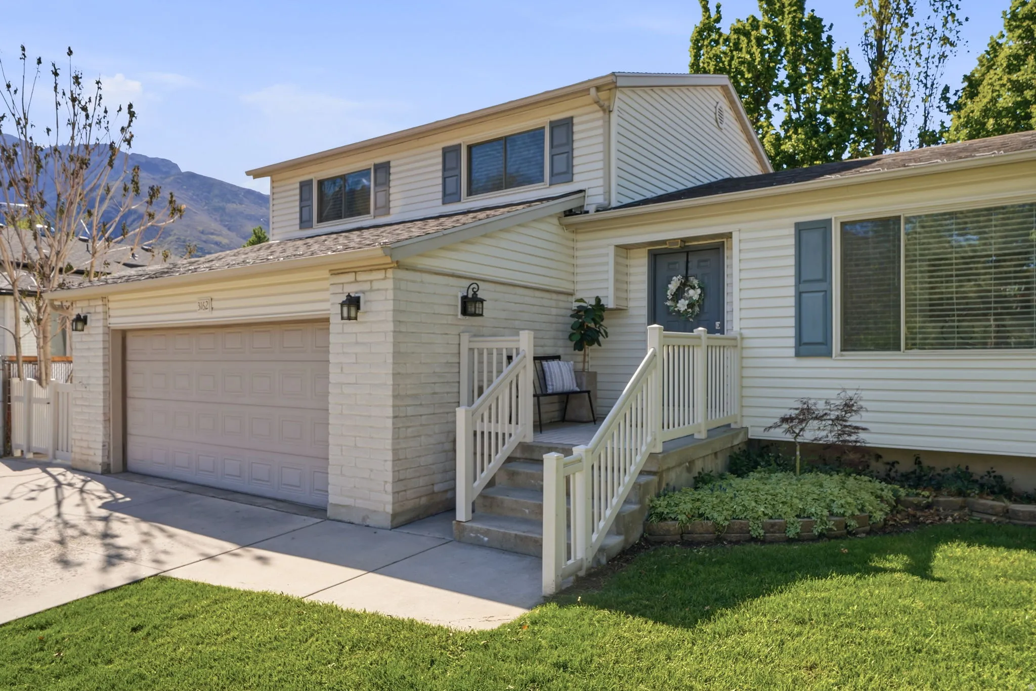 Traditional-style home with concrete driveway, a garage, a front yard, and brick siding