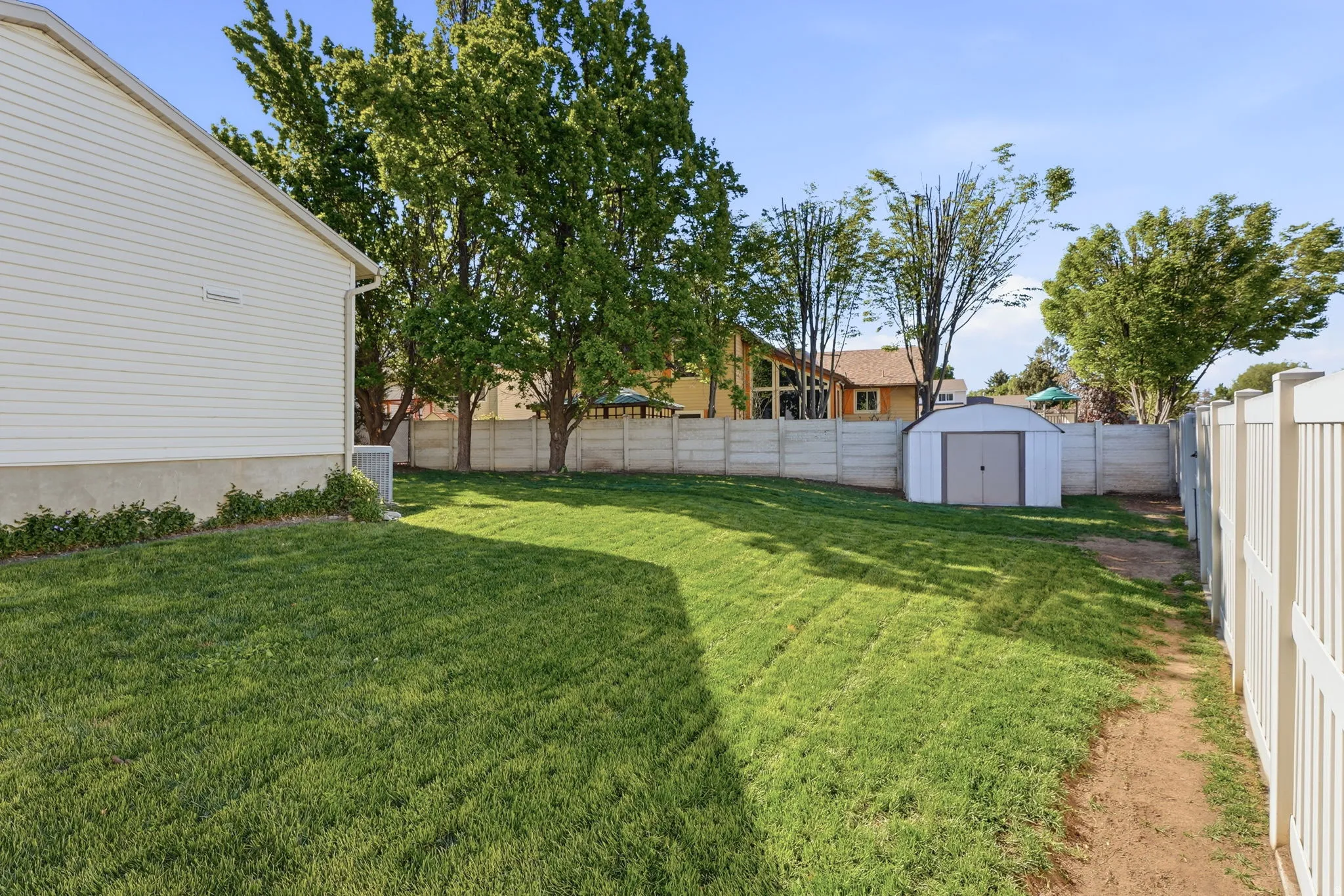 Fenced backyard with a storage unit