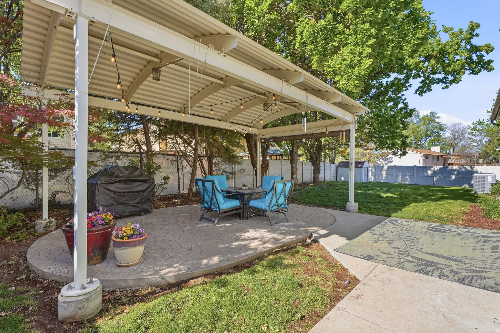Fenced backyard with a patio area, a grill, and outdoor dining space