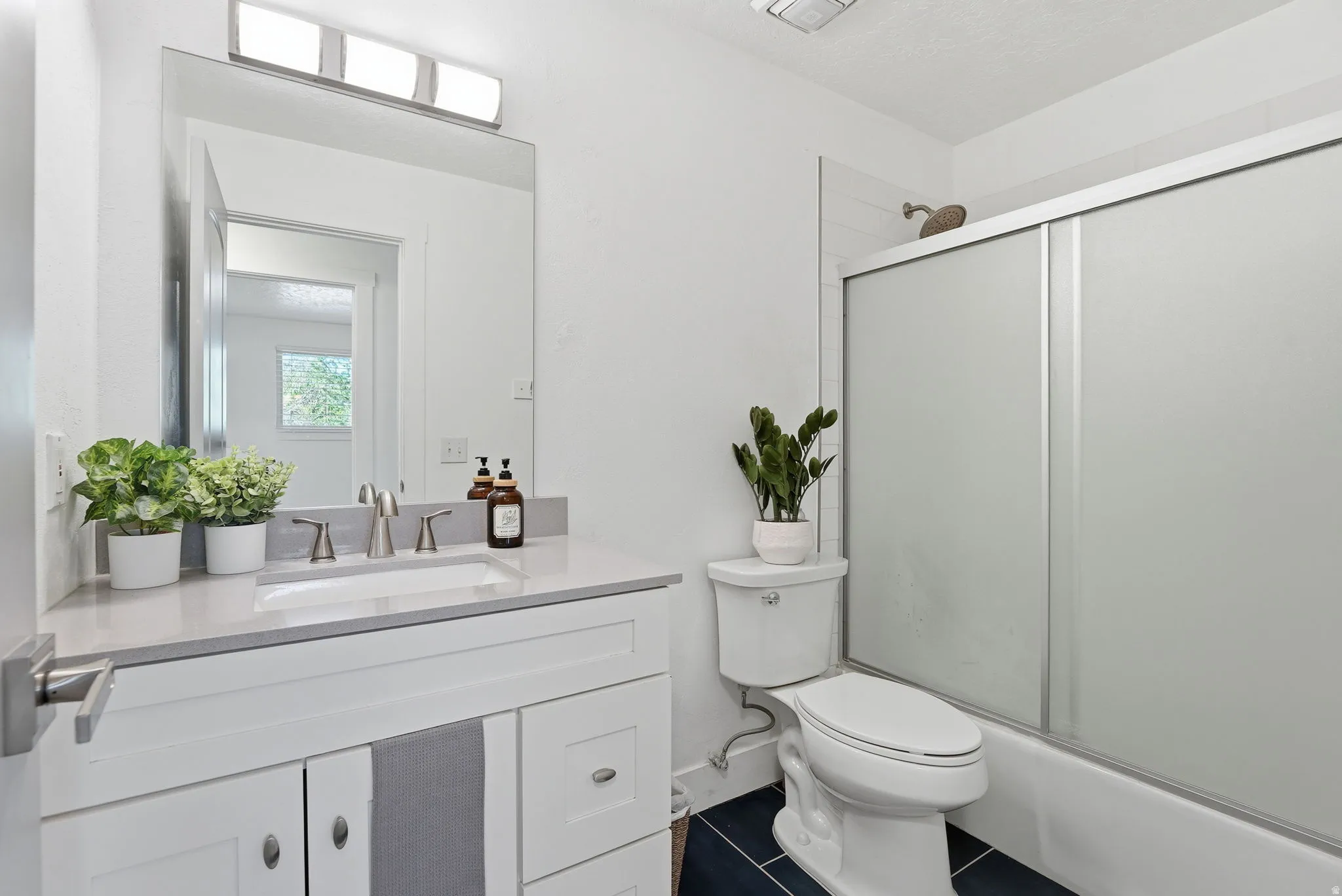 Bathroom featuring vanity and dark tile patterned floors