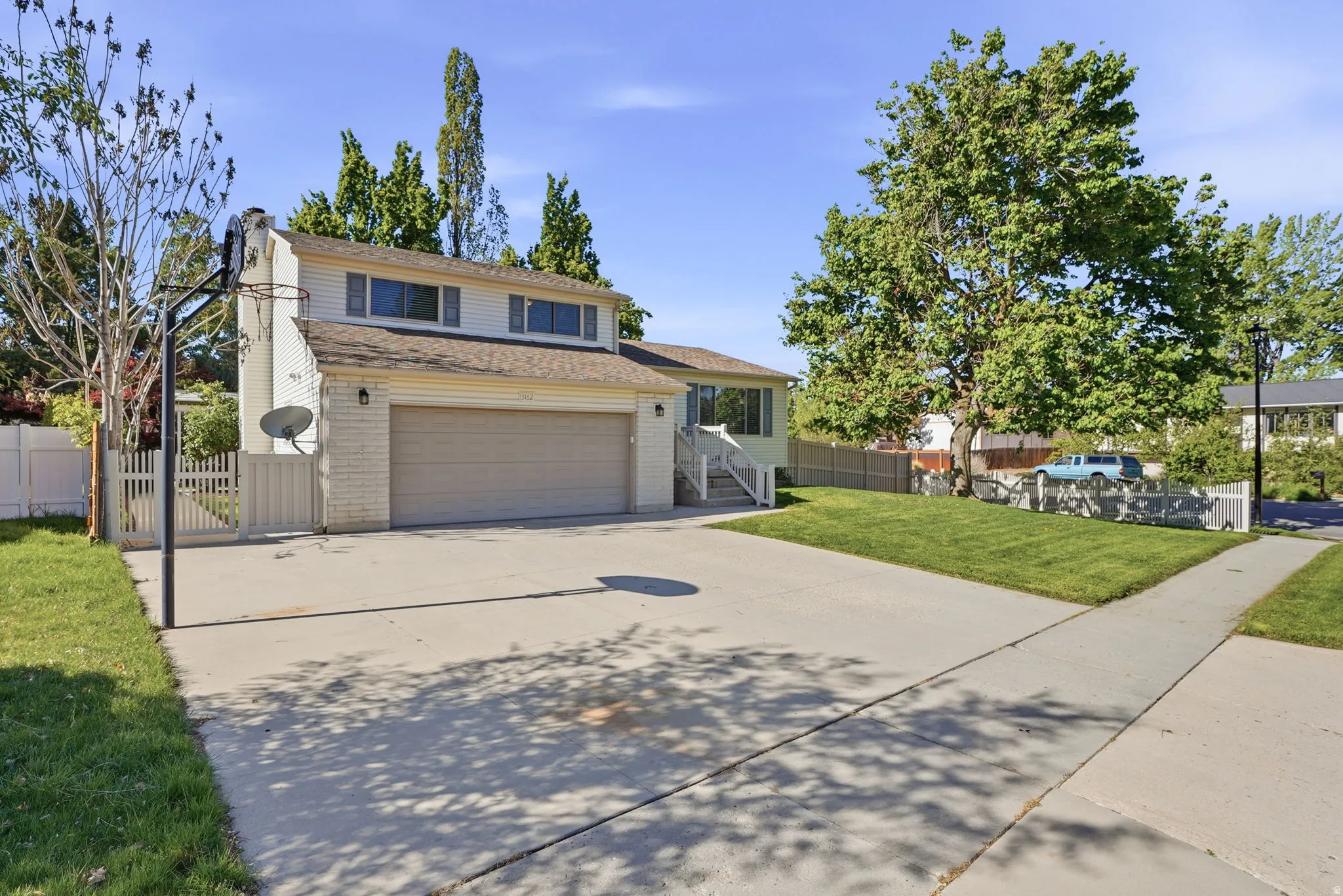 View of front of house featuring driveway, brick siding, a chimney, and an attached garage