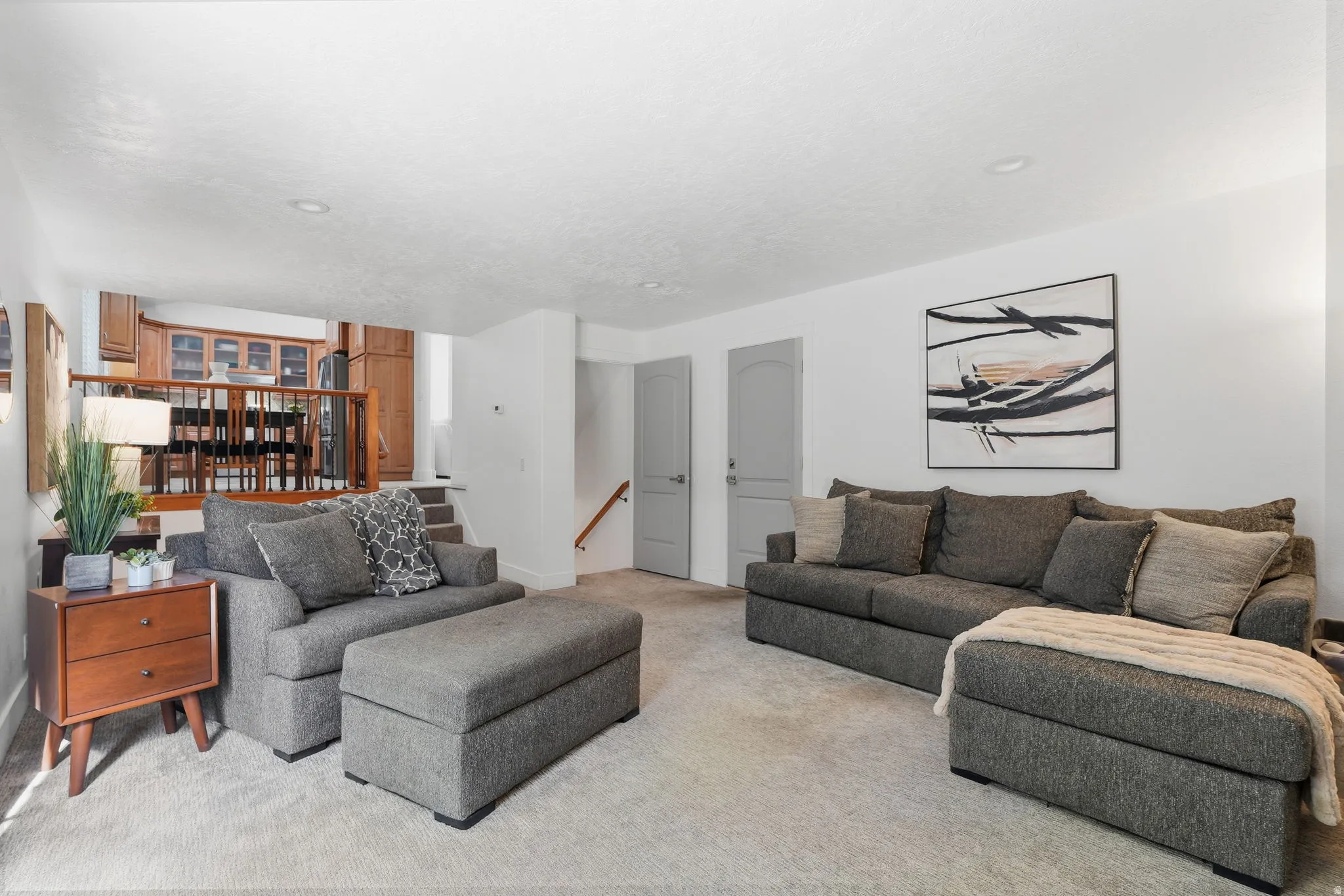 Carpeted living area featuring stairs