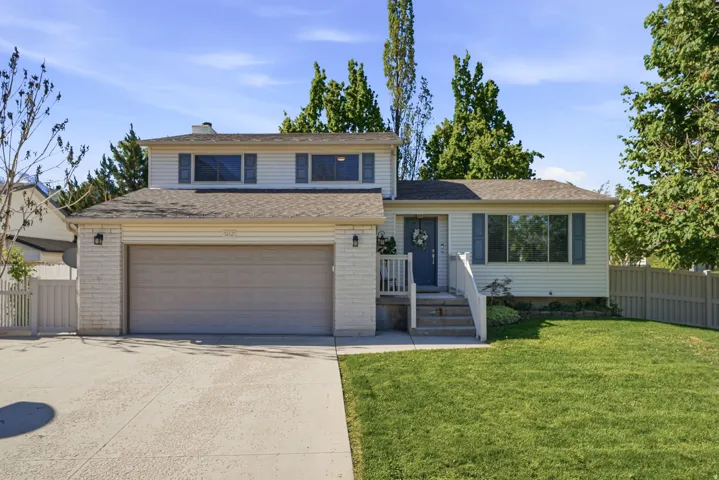 Traditional home featuring concrete driveway, a garage, and brick siding