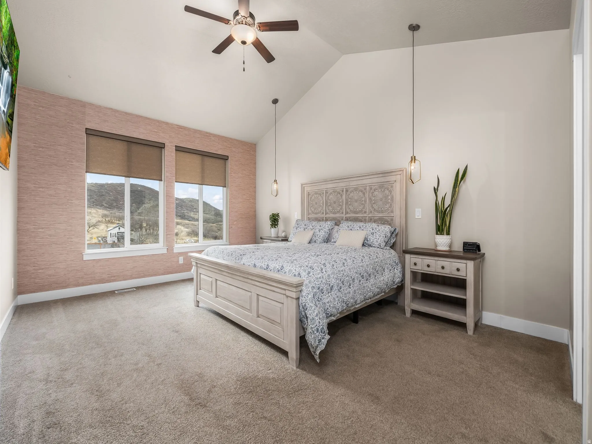 Large primary bedroom featuring high vaulted ceilings.