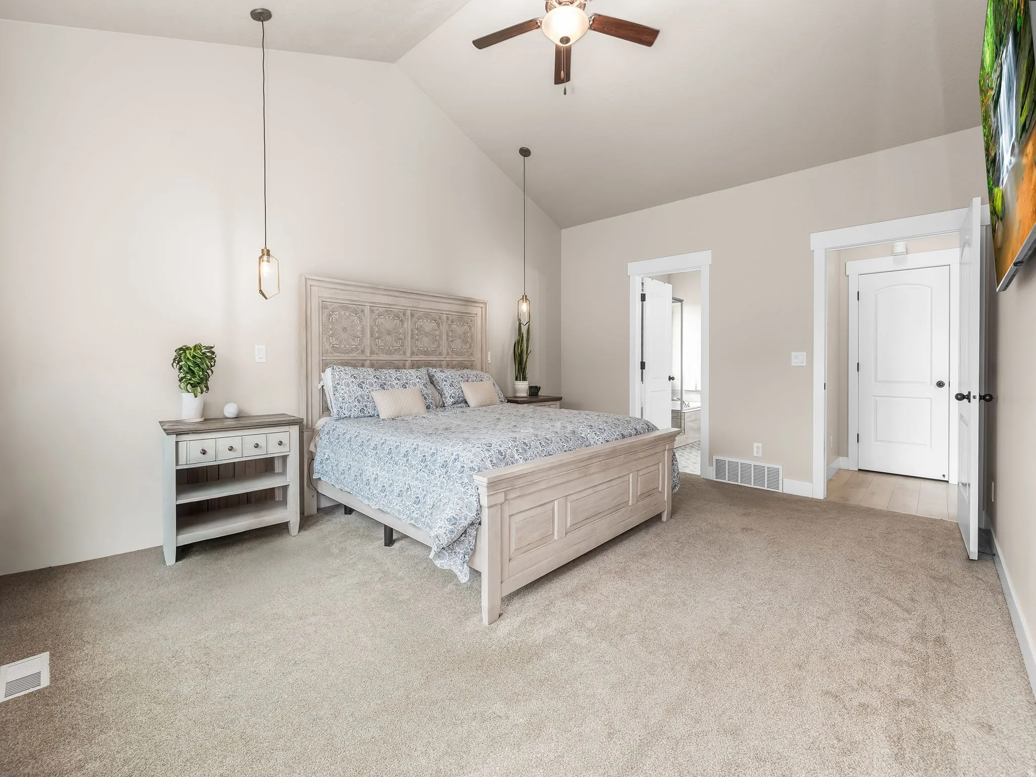 Large primary bedroom featuring high vaulted ceilings.