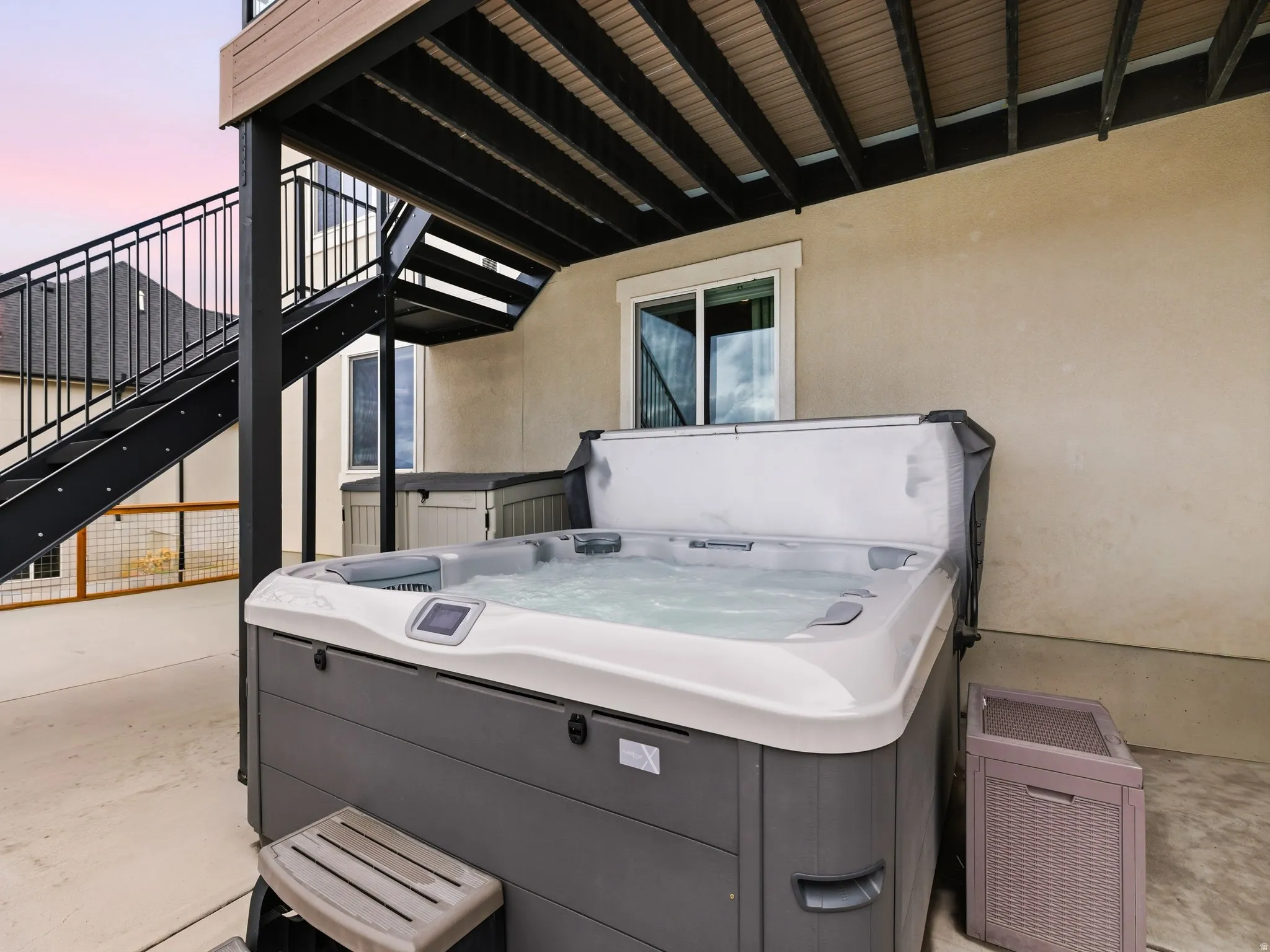 Covered hot tub area under the upper deck.