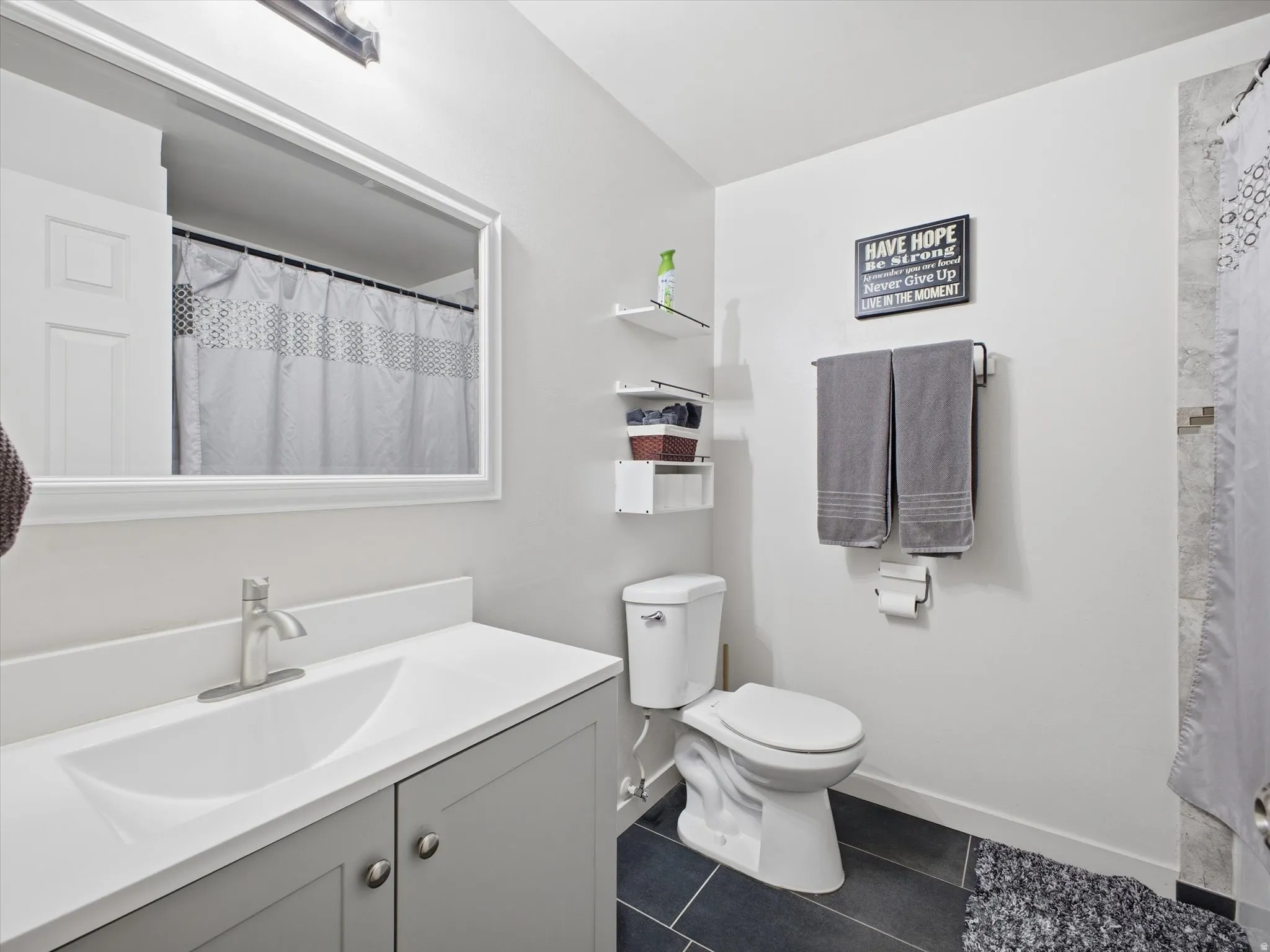 Bathroom with vanity, full bath and dark tile patterned floors