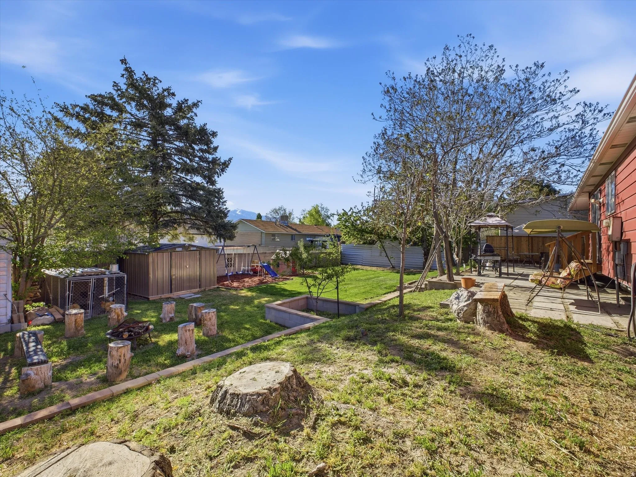 Fenced backyard featuring a patio area and a shed