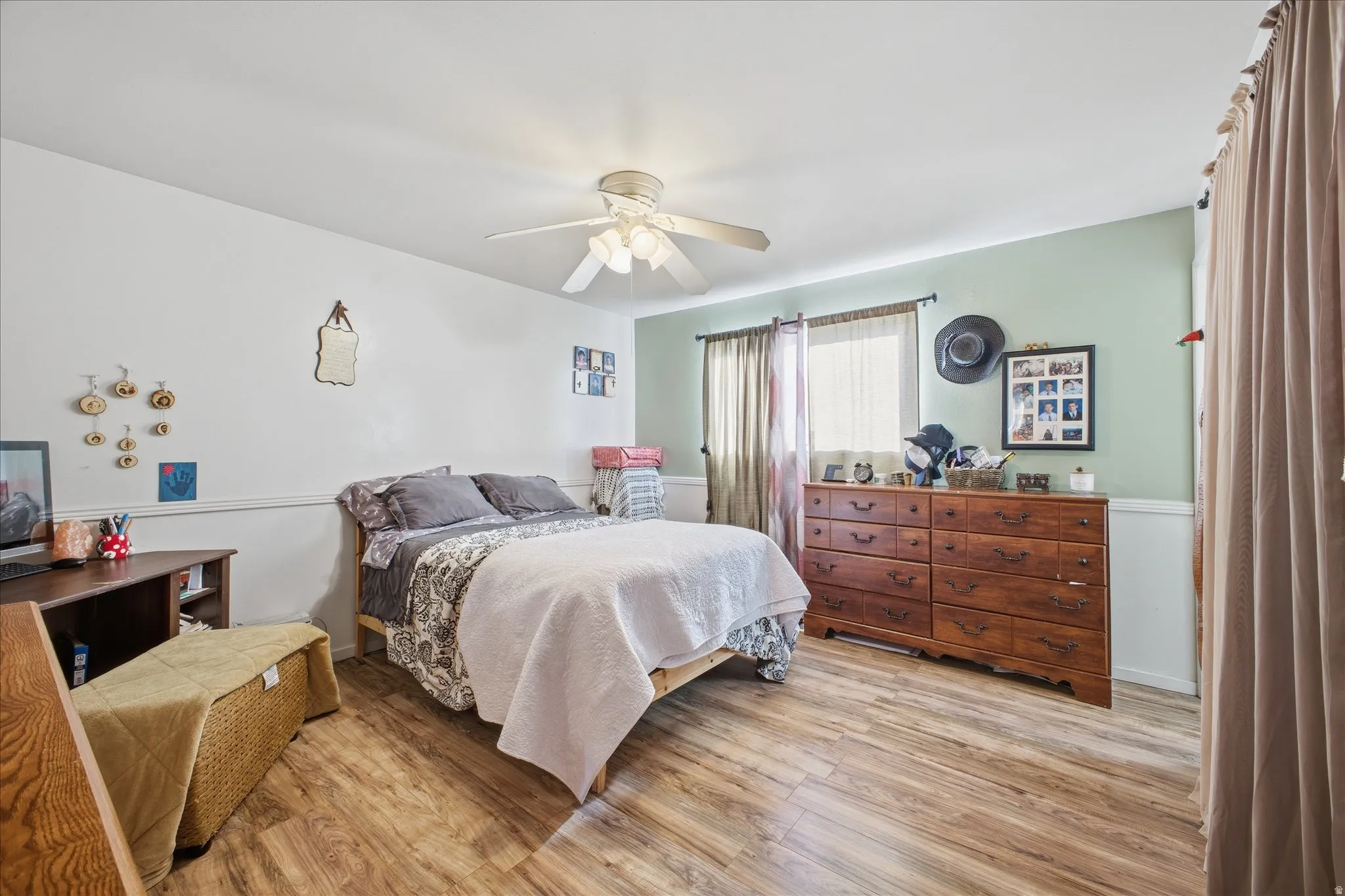 Primary bedroom featuring light wood-type flooring and ceiling fan
