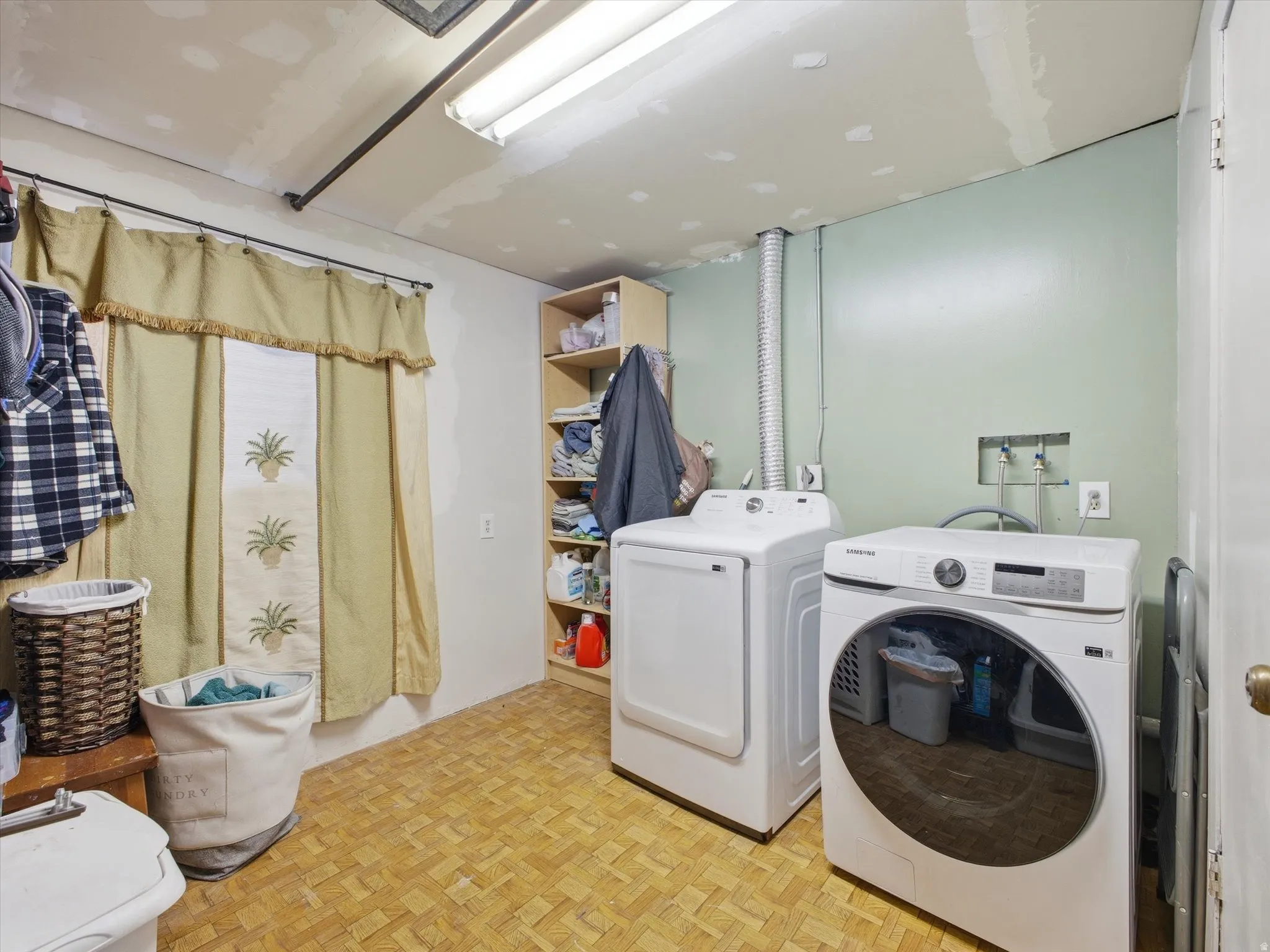 Laundry area featuring parquet flooring.