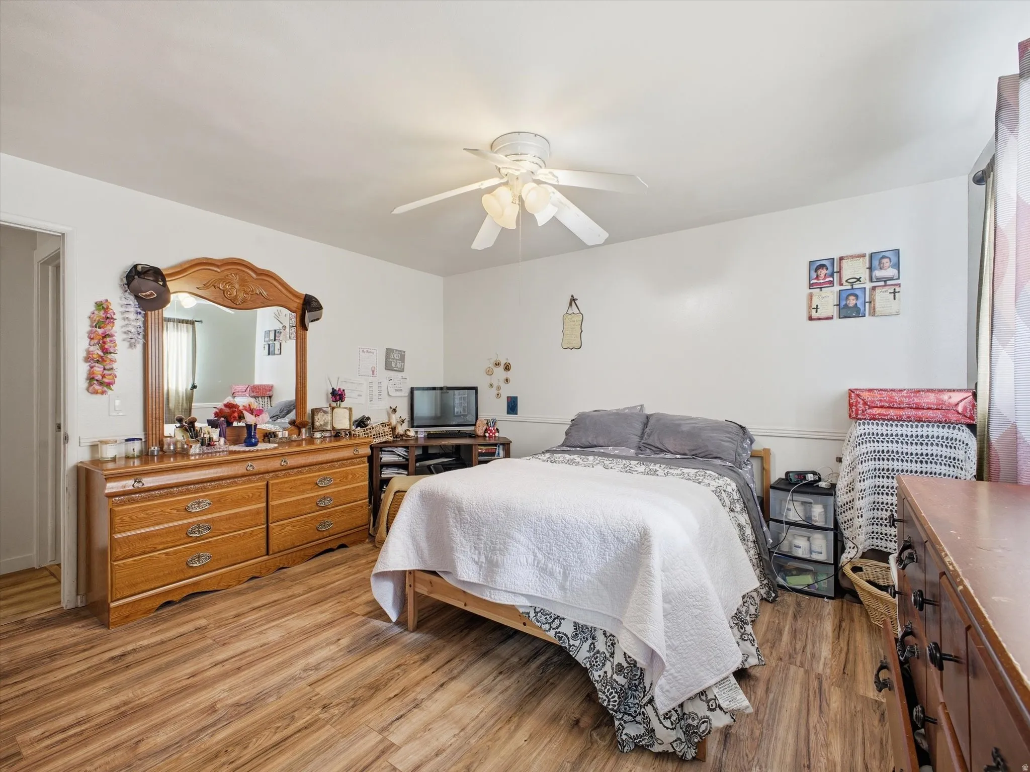 Primary bedroom with light wood-style floors and ceiling fan