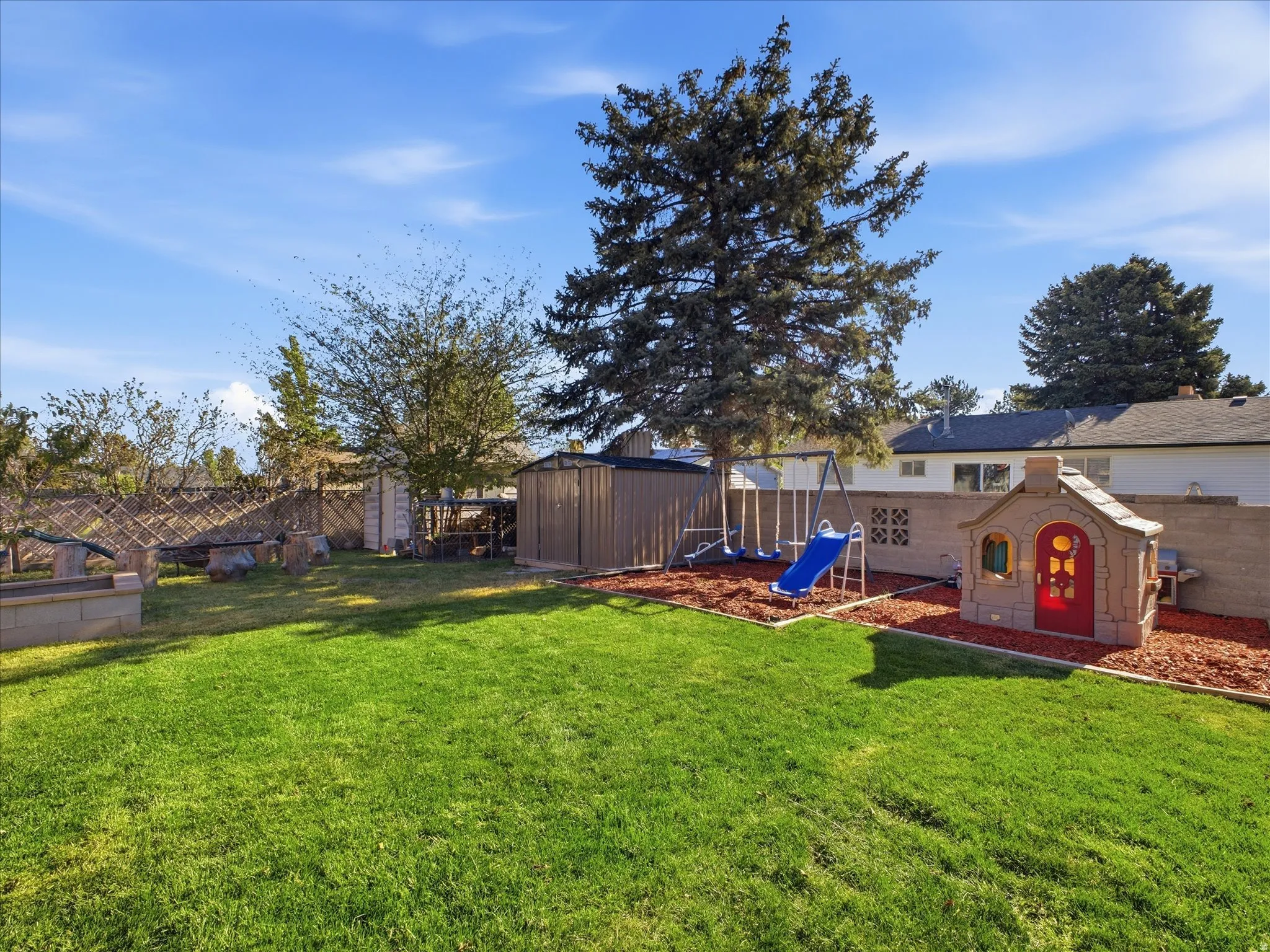 Fenced backyard featuring a storage shed
