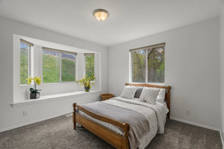 Bedroom featuring dark carpet and baseboards