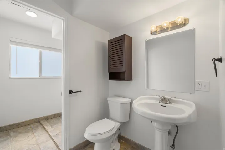 Half bathroom featuring toilet and baseboards