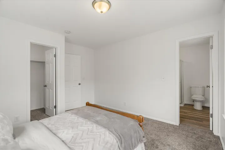 Carpeted bedroom with a spacious closet and ensuite bath