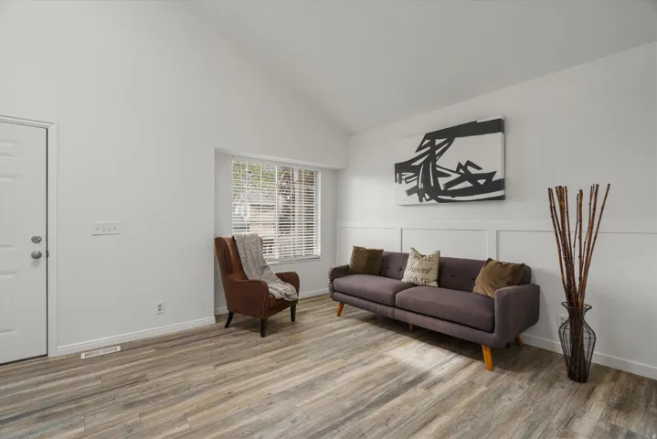 Sitting room with vaulted ceiling and light wood finished floors