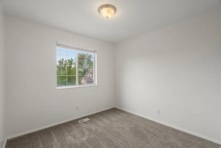 Empty room featuring dark carpet and baseboards
