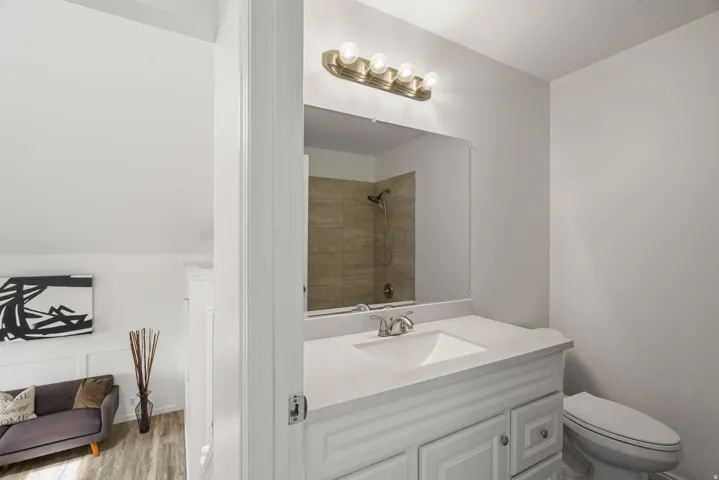 Bathroom with vanity, a tile shower, and light wood-type flooring