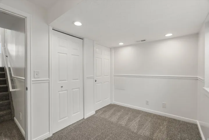 Basement featuring dark carpet and recessed lighting
