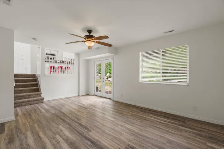 Unfurnished living room with a ceiling fan and dark wood-style flooring
