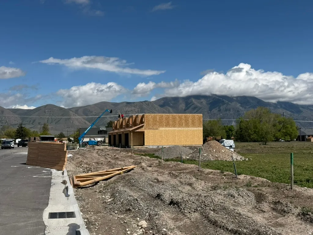New construction framing in progress with structural wood sheathing and roof trusses visible