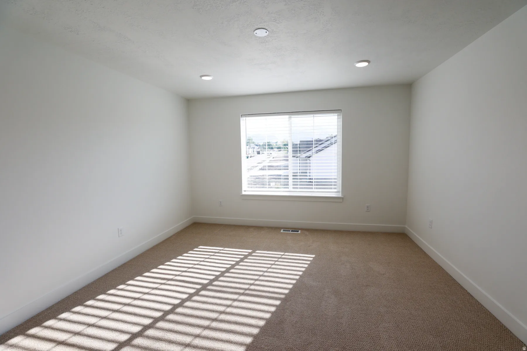 Empty room with baseboards and light colored carpet