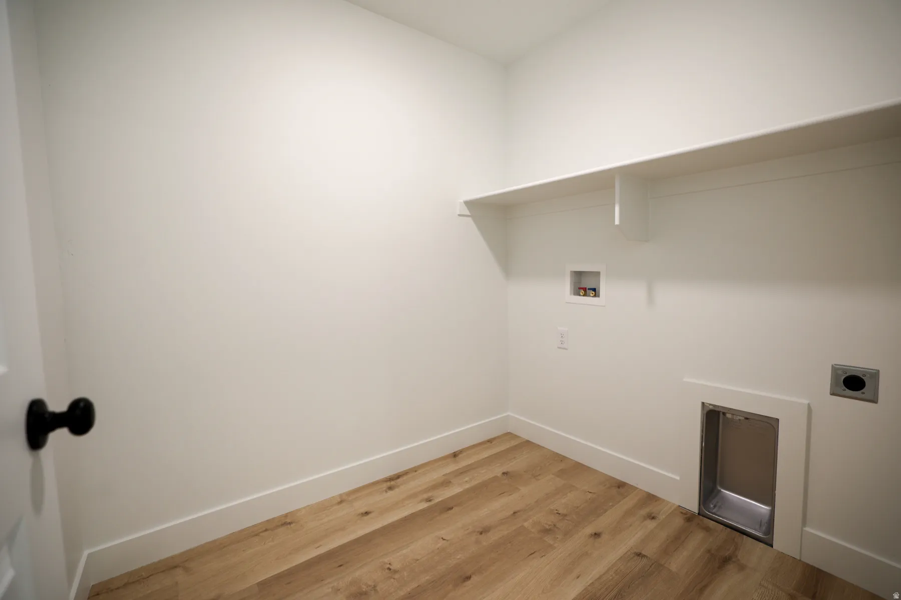 Laundry area featuring light wood-style floors, hookup for a washing machine, and hookup for an electric dryer