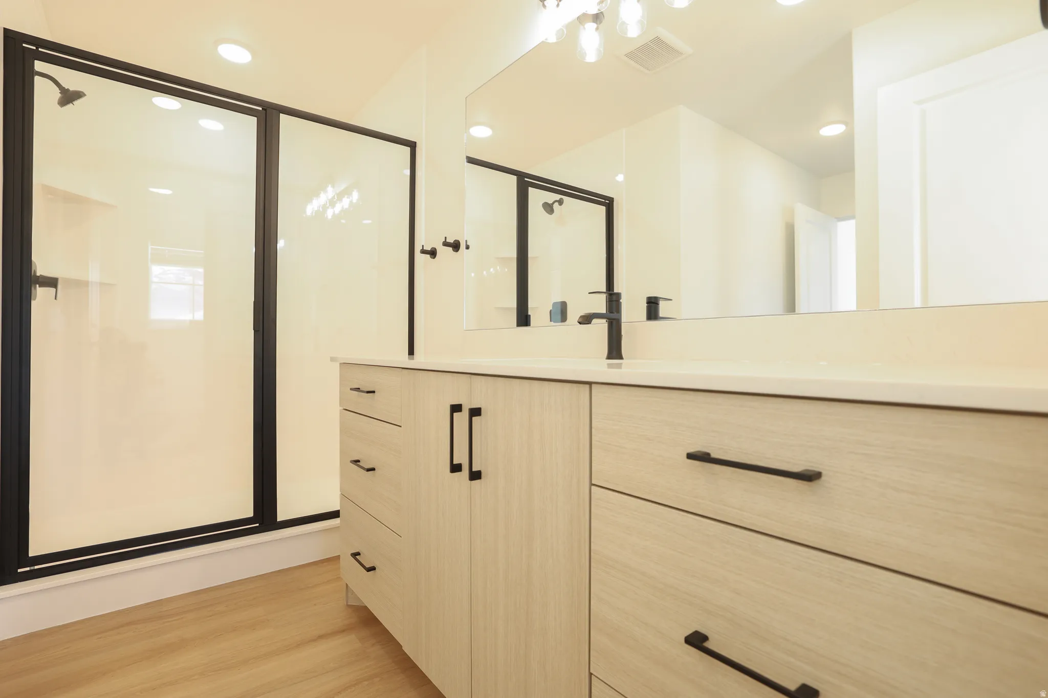 Bathroom featuring a stall shower, vanity, recessed lighting, and light wood-style flooring