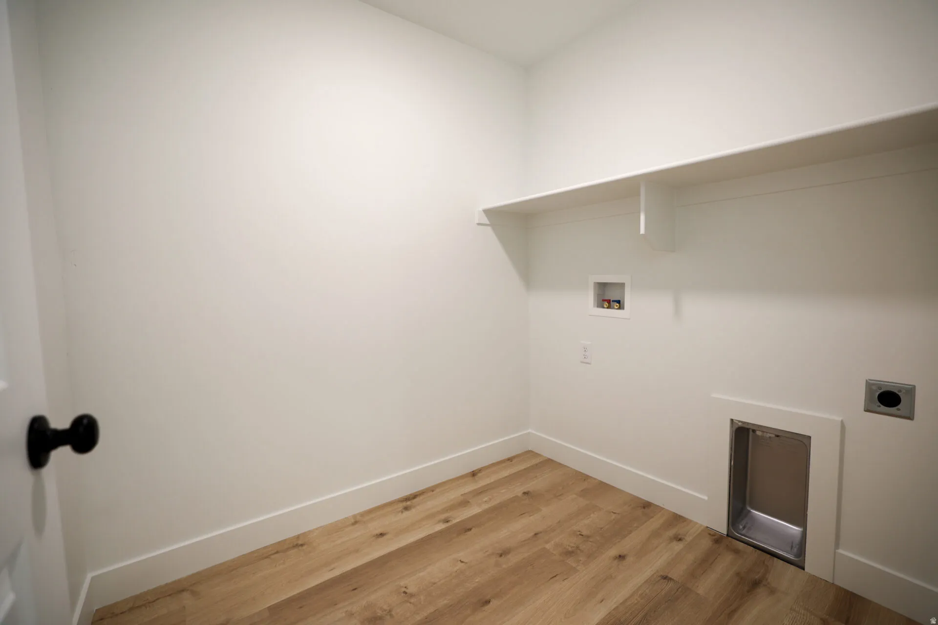 Laundry room with light wood-style flooring, hookup for a washing machine, and hookup for an electric dryer