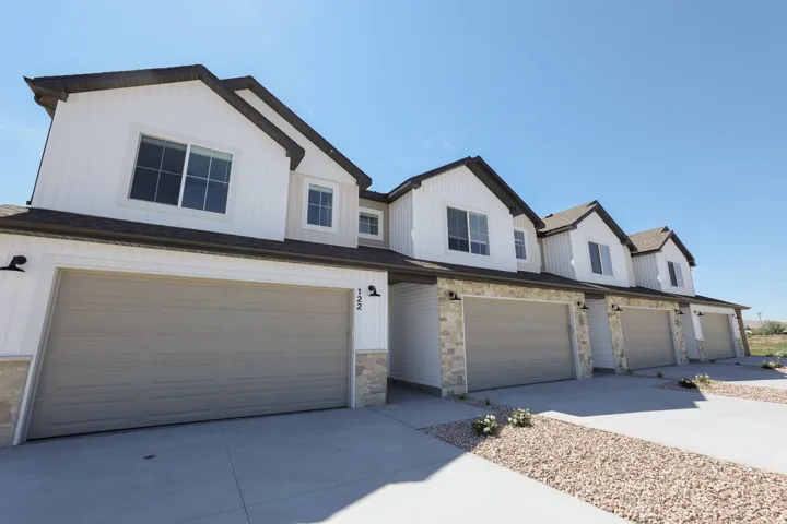 Modern townhome exterior with crisp white siding and dark trim