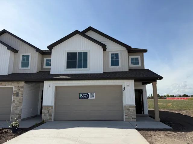 Two-story exterior with vertical and horizontal siding, stone veneer accents, and a dark shingle roof