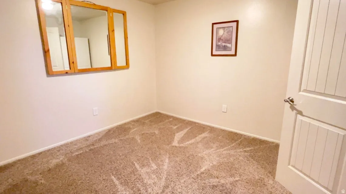 Unfurnished room featuring light colored carpet and baseboards
