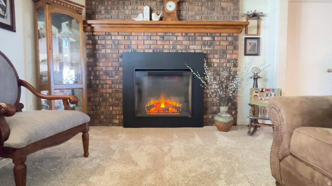 Detailed view of a brick fireplace and carpet flooring