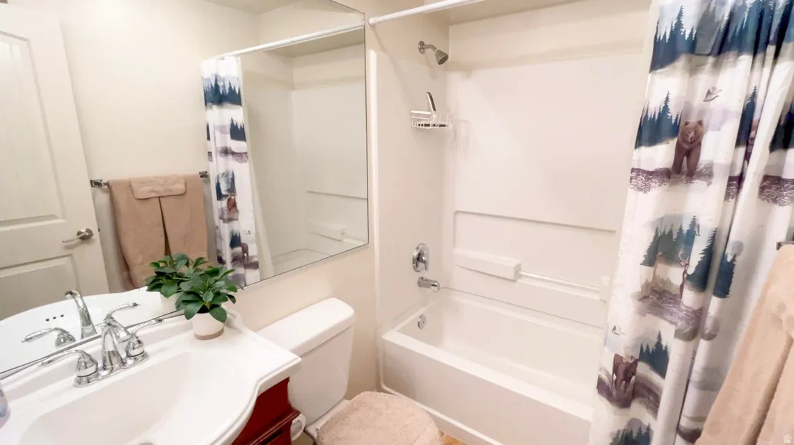 Bathroom featuring vanity and shower / tub combo with curtain