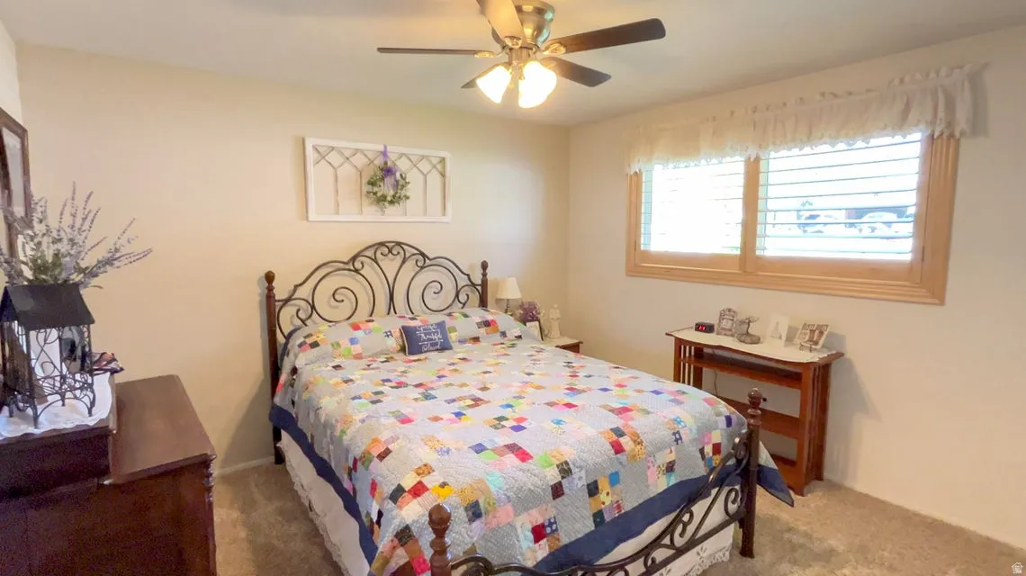 Carpeted bedroom with ceiling fan