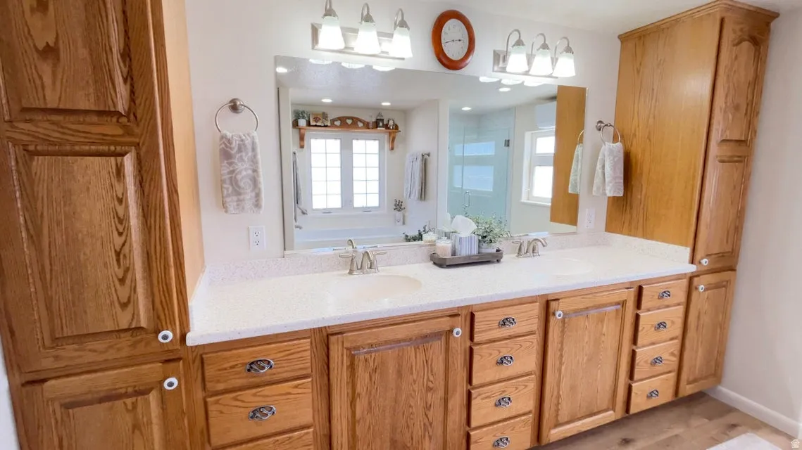 Bathroom featuring double vanity, a stall shower, and a garden tub